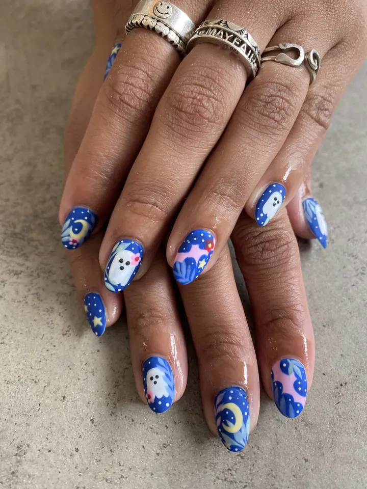 Blue nails with hand-painted ghosts, stars and moons