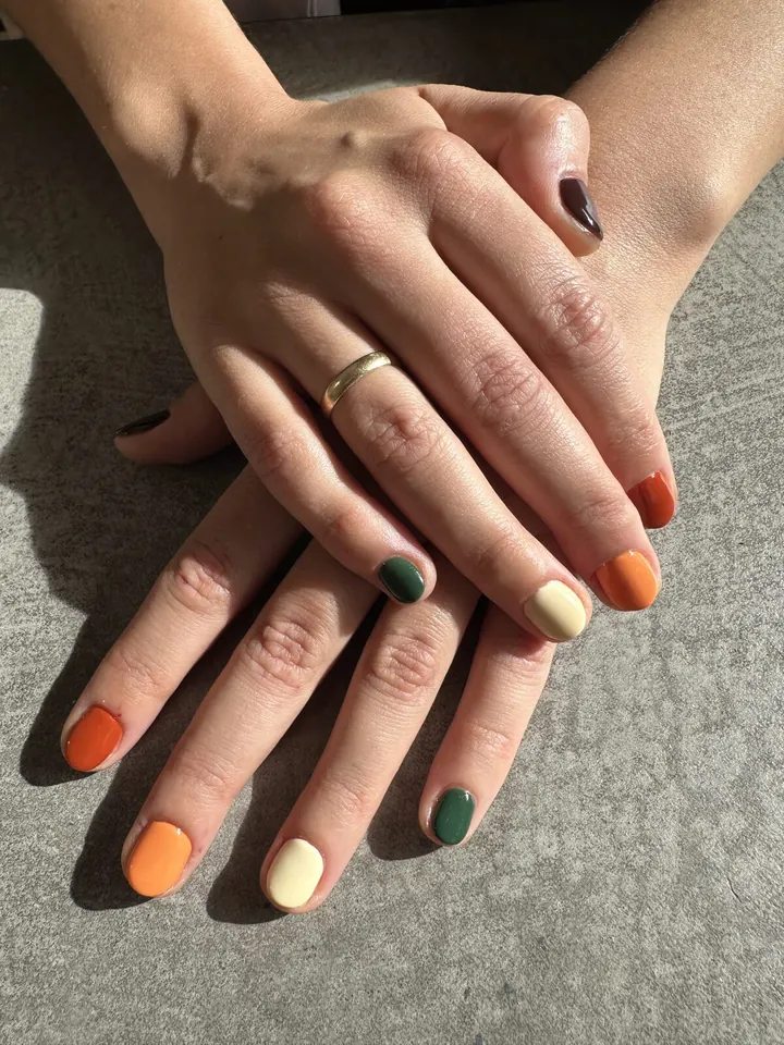 Ungles curtes amb colors de tardor: taronja, crema, verd fosc i marró