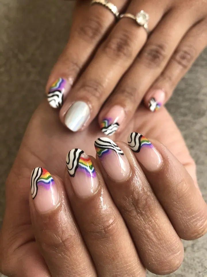 Uñas con ondas en blanco y negro, arcoíris y una uña cromada